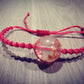 Pulsera tejida rosada con flores secas