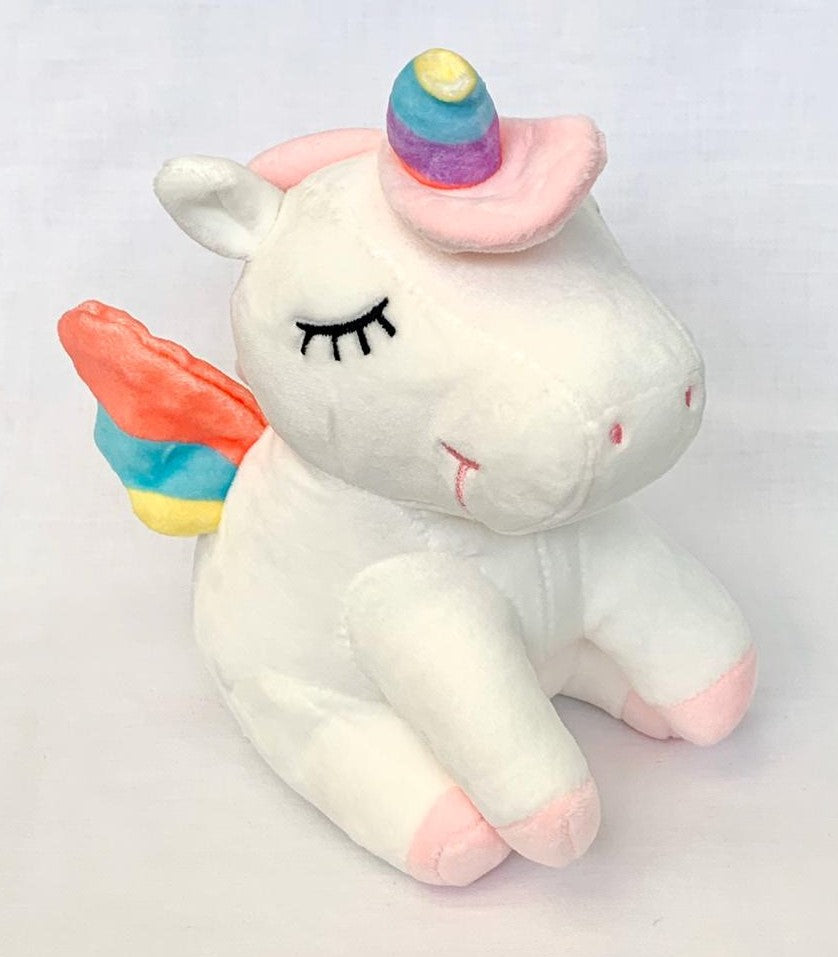 Unicornio de peluche dormido color blanco.
