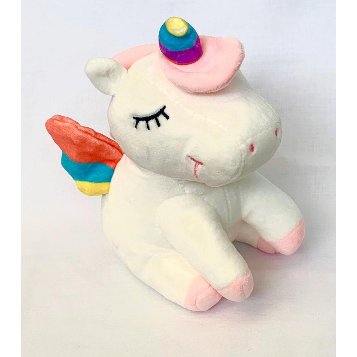 Unicornio de peluche dormido color blanco.